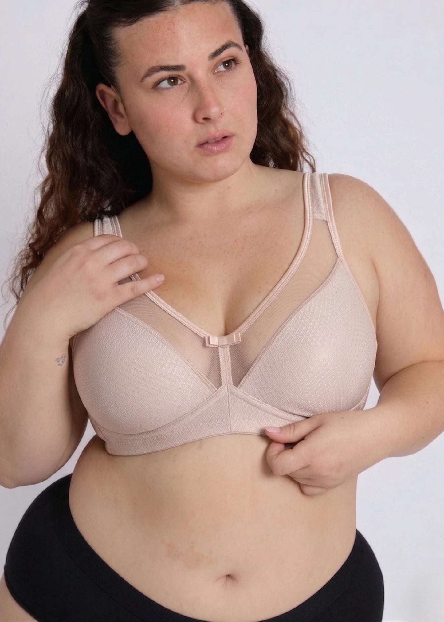 Model posing in a beige supportive bra designed for heavy breasts