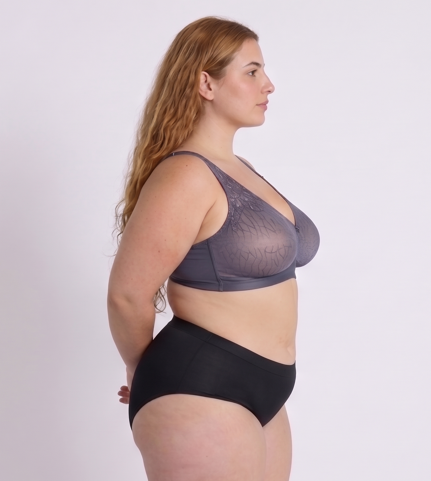 Woman wearing a purple-grey supportive bra for large bust side view