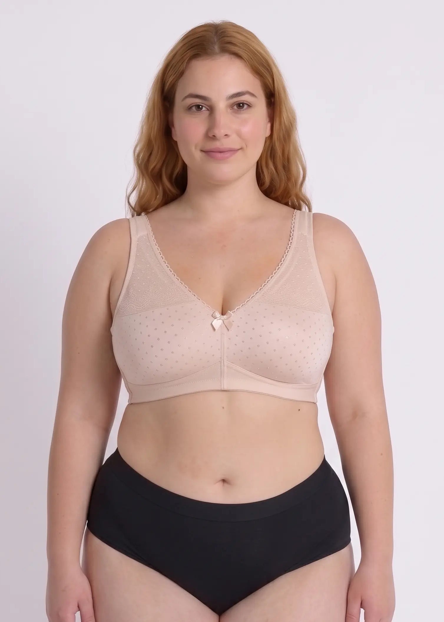 Front view of a model with a full bust wearing a supportive beige bra, highlighting the comfortable full-coverage cups with dotted fabric and lace edges.