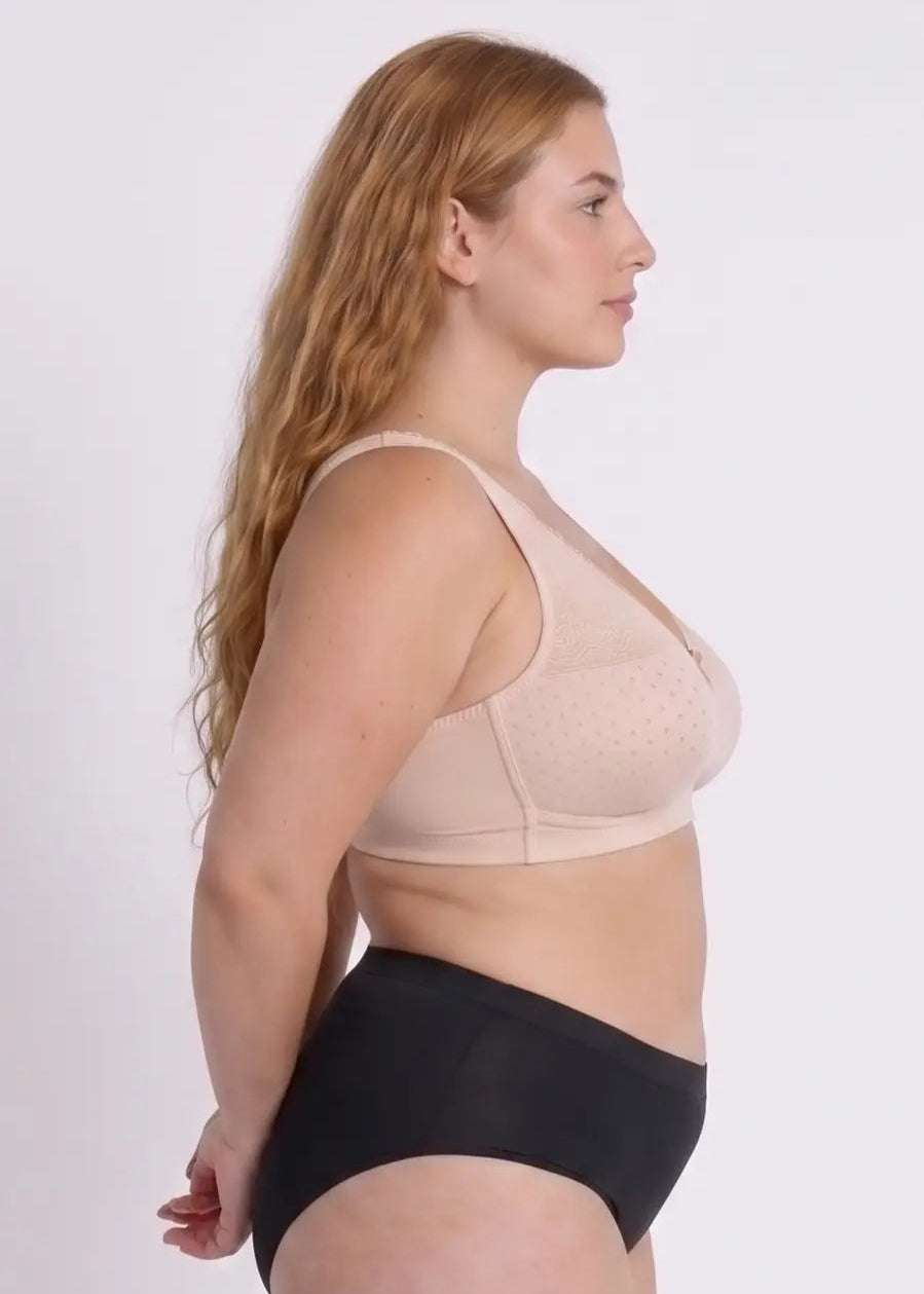 Side profile of a model demonstrating the fit, natural lift, and excellent side coverage of a beige dotted bra designed for full-busted women.