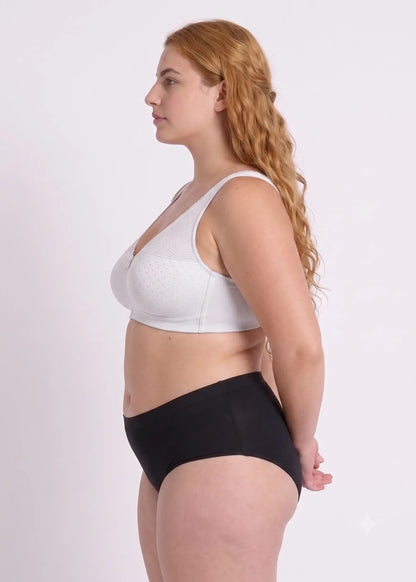 Profile view of a model showcasing the side support, comfortable fit, and natural lift of a white dotted bra designed for full coverage.