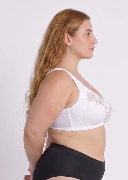 Side profile view of a model wearing a supportive white wire-free bra, demonstrating natural lift, full side coverage, and comfortable cotton-lined cups suitable for daily wear or yoga.