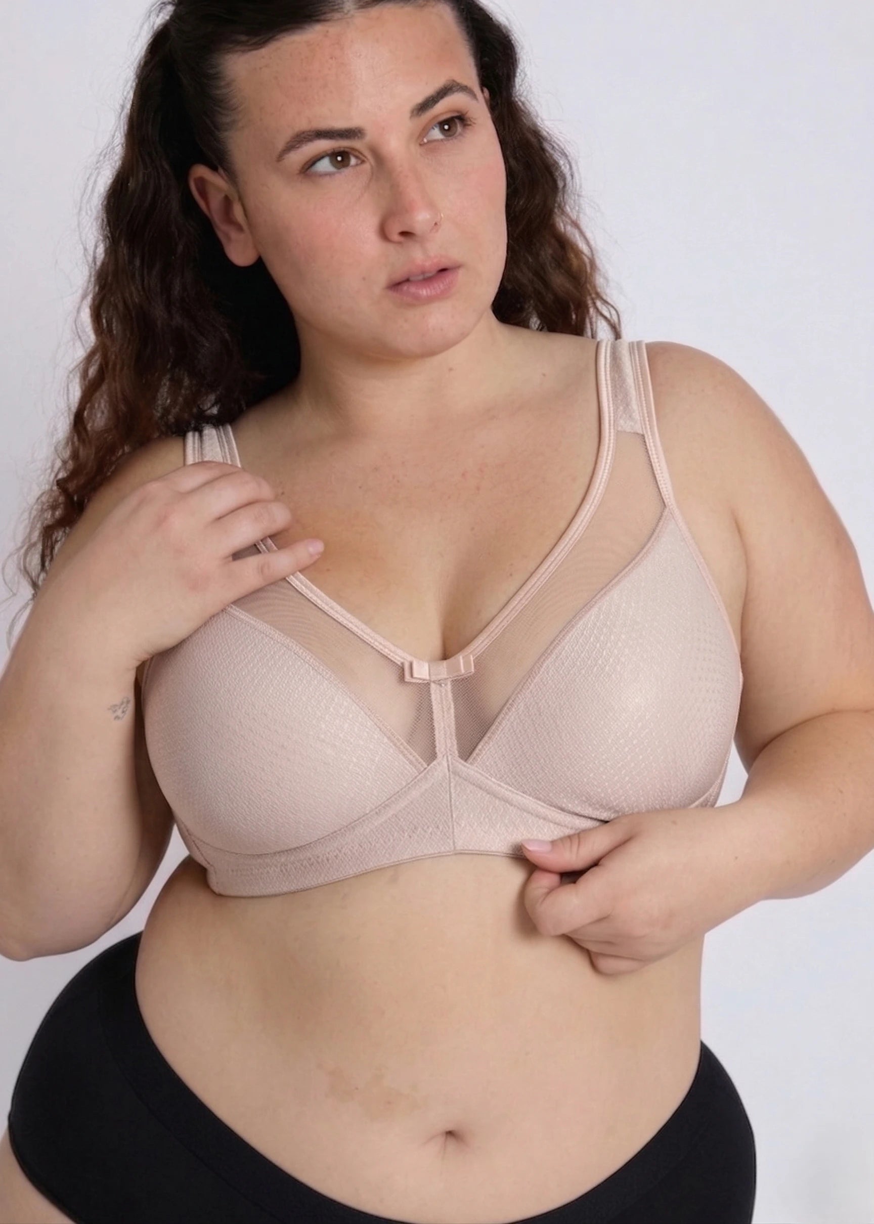 Model posing in a beige supportive bra designed for heavy breasts