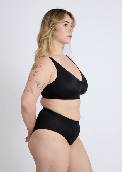 NewG Doni black wireless bra for large busts, profile view on a plus-size model showing smooth side support and fit, against a seamless white background.