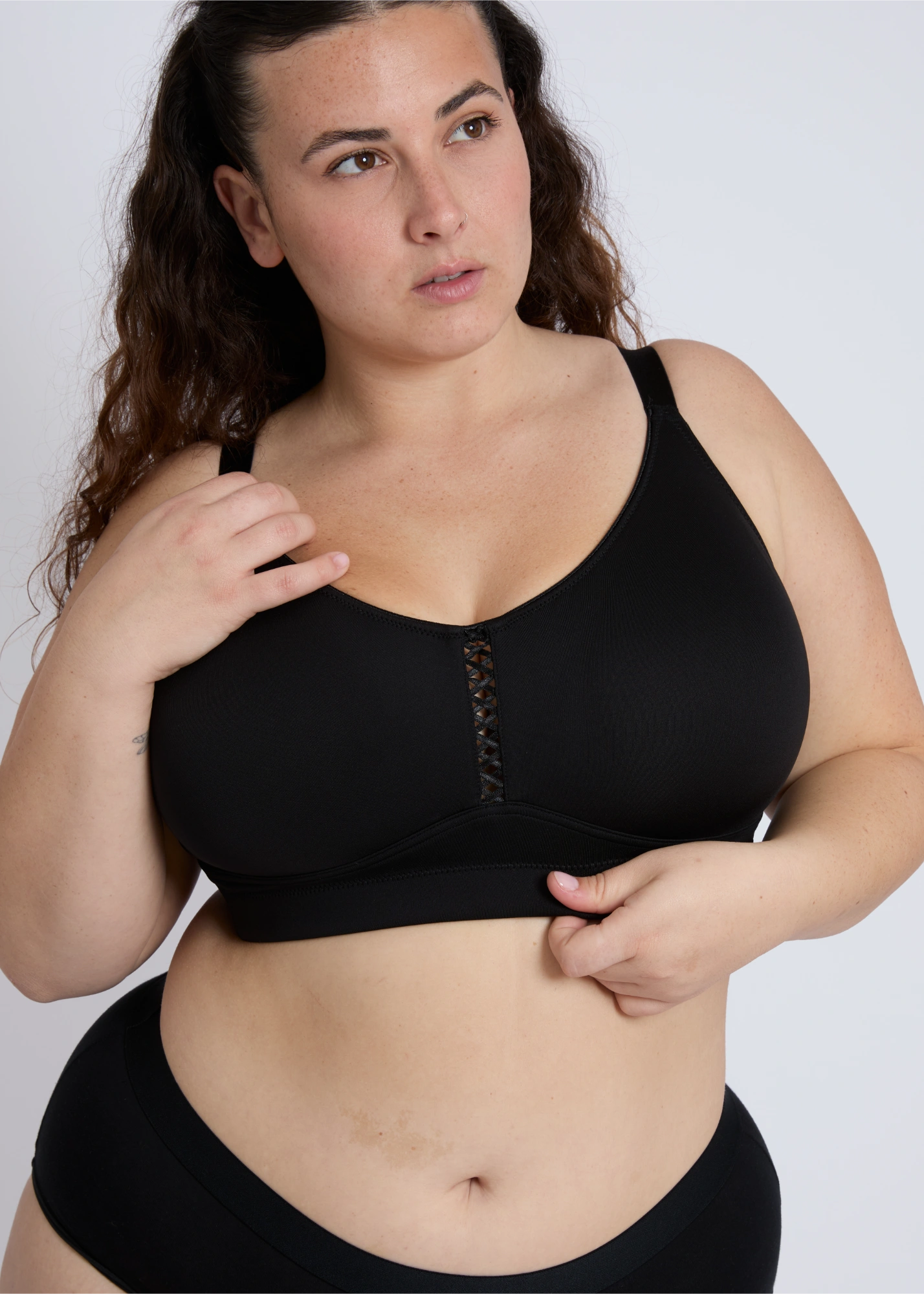 A close-up view of the black Joy seamless wire-free bra for large breasts, showing the criss-cross center detail and the flexible, supportive under-bust band