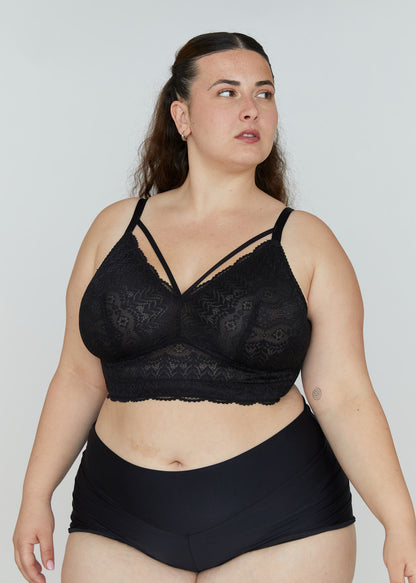 A front three-quarter view of the black Mia wire-free lace bra for large breasts on a model, highlighting the front cross-straps and side coverage