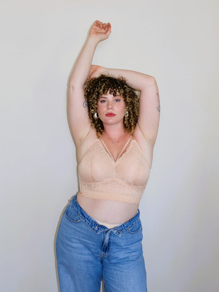 Model with arms raised wearing the nude Mia wire-free lace bra for large breasts, demonstrating a secure fit and stability