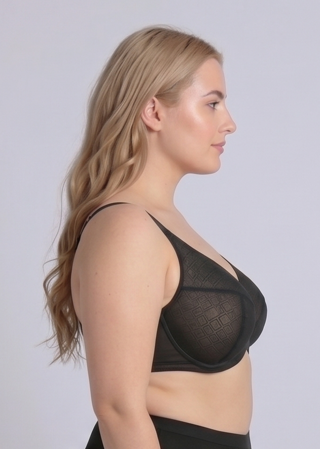 Side profile view of a plus-size model wearing the NewG Bella black underwire minimizer bra, showcasing the supportive side fit and geometric patterned mesh cups for large busts.
