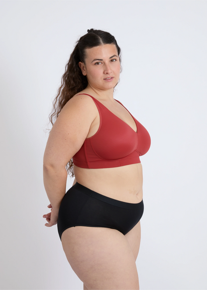 Side profile of the NewG Doni red wireless bra for large busts, showing the seamless fit and comfortable support on a plus-size model