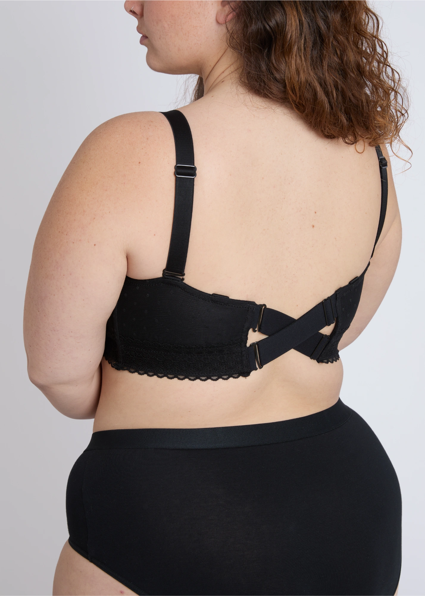 The adjustable criss-cross back design of a black nursing bra for extra large bust support