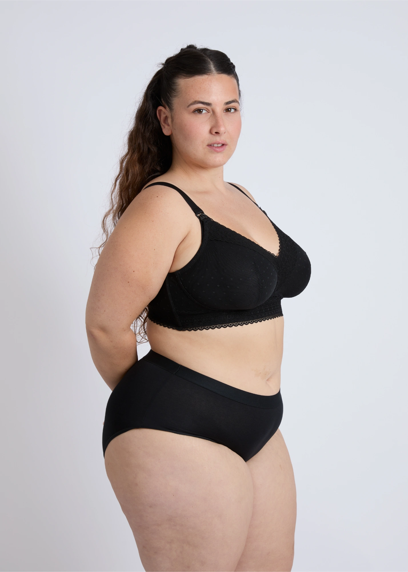 Side profile of a supportive black open-back nursing bra for large breasts