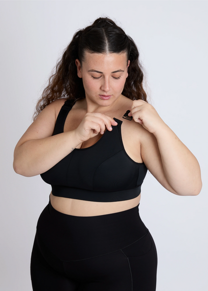 Close-up of a black sports bra for big breasts with the front clip open for easy access