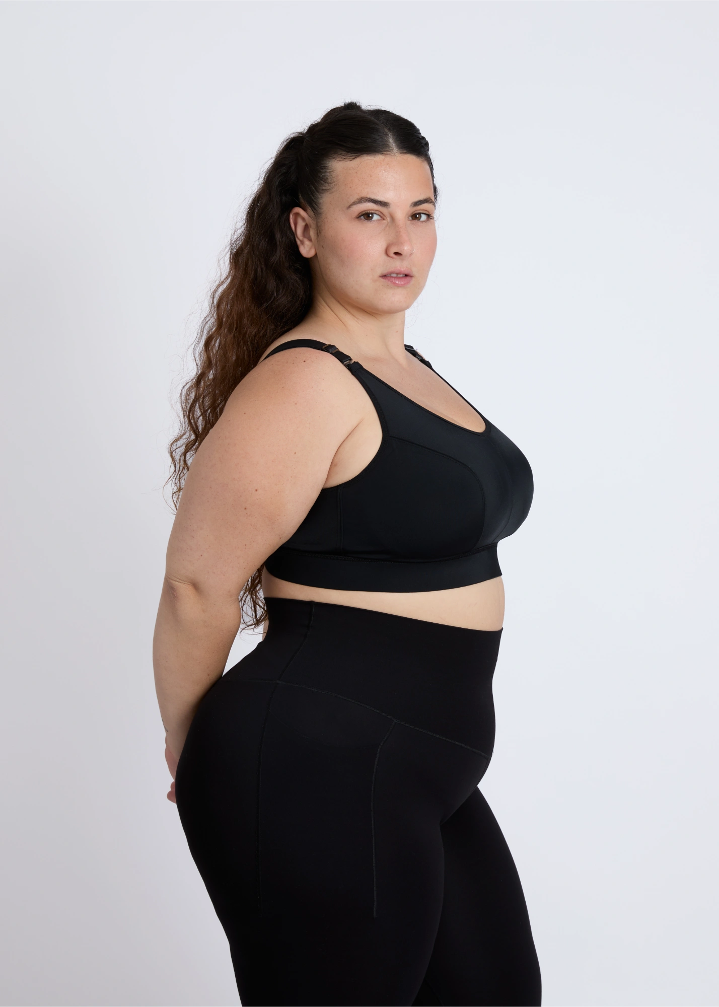 Side profile of a black high-impact sports bra for big breasts showing full side coverage