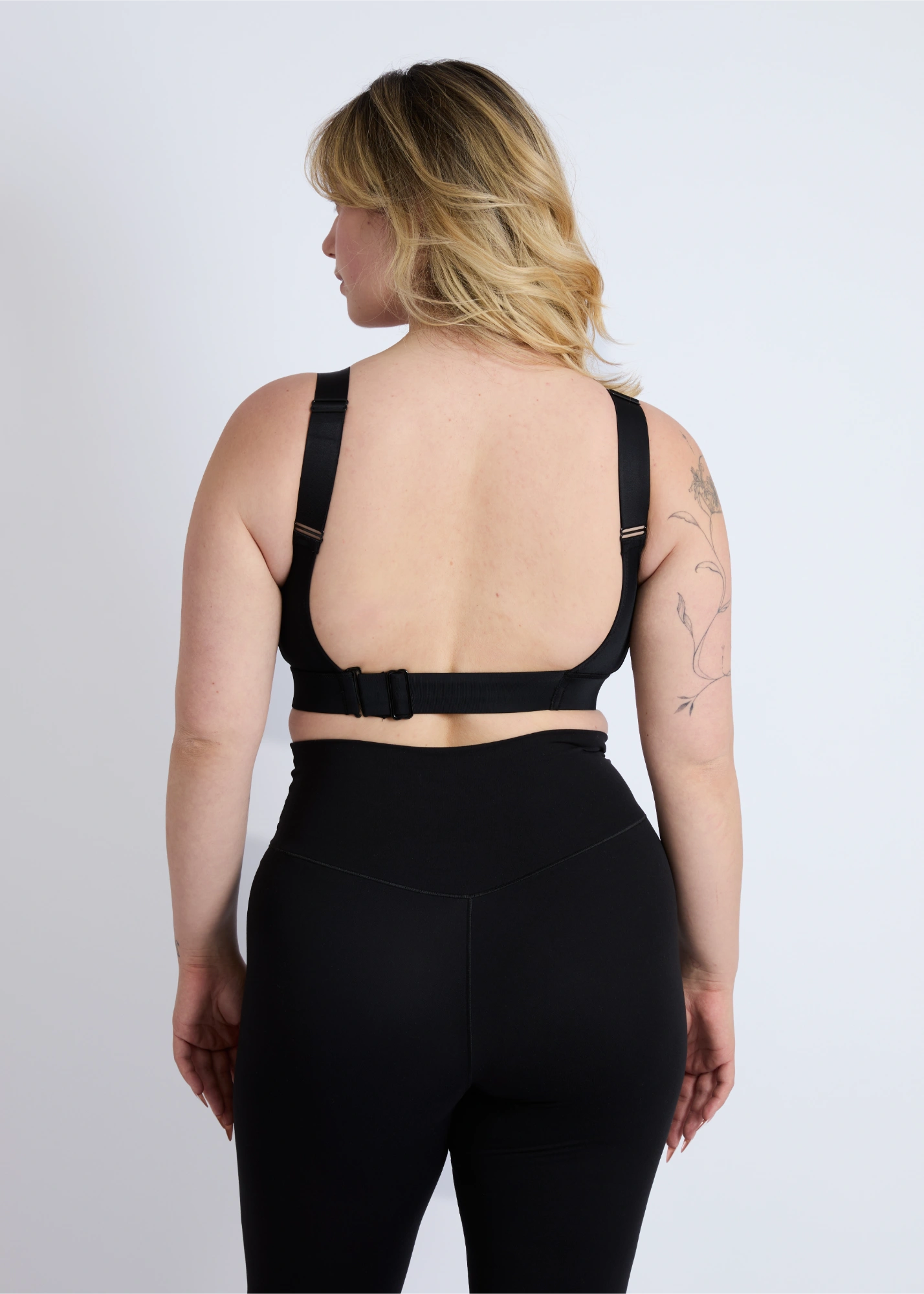 Back view of a black high-impact sports bra for large breasts showing the wide supportive band