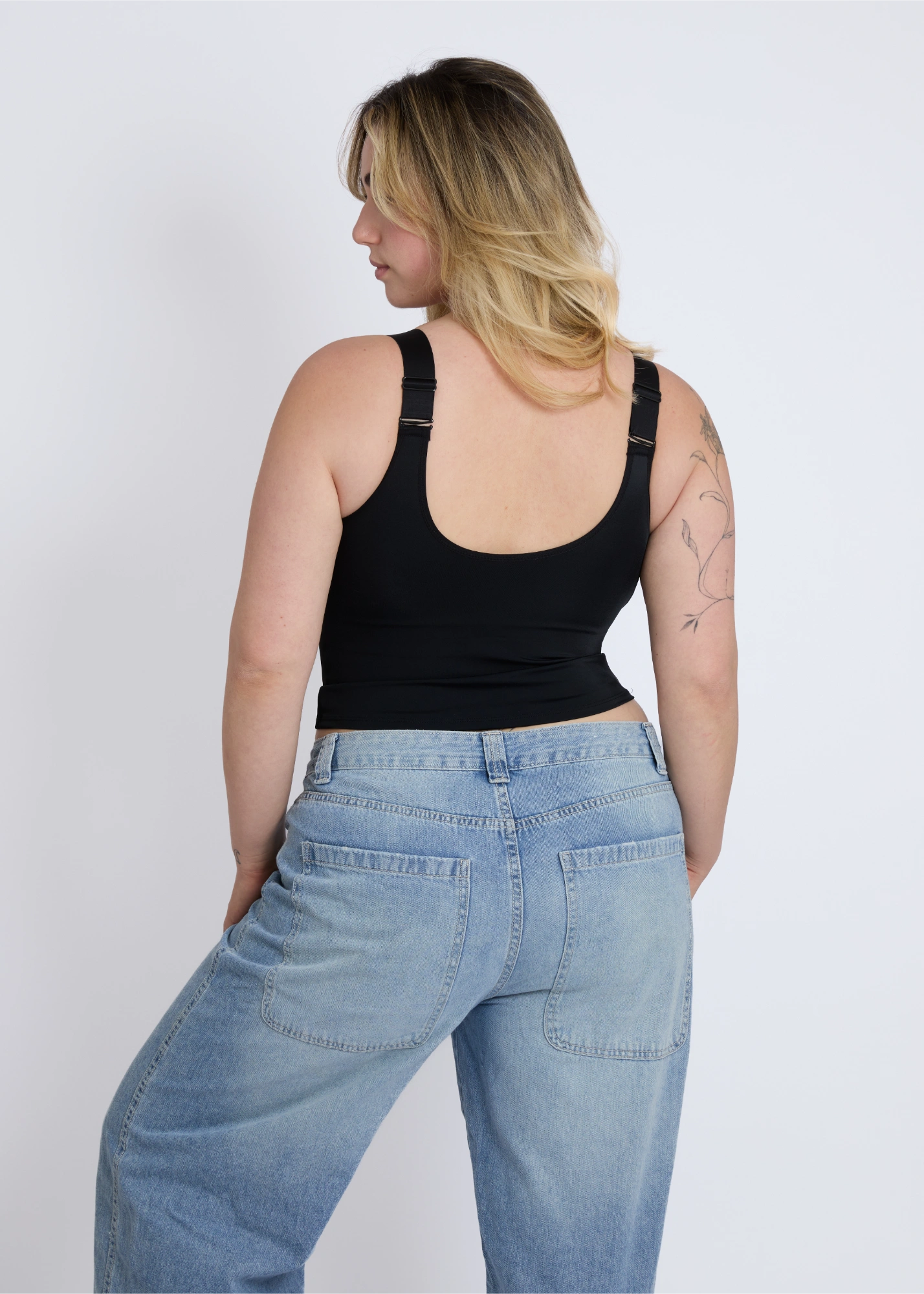 The sleek back view of a black supportive tank top for large breasts with a built-in bra providing full coverage